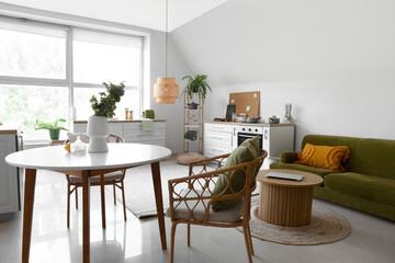 Vase with eucalyptus branches on dining table in modern kitchen