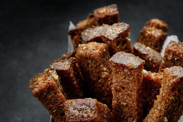 Crackers from dark bread with garlic, on a dark. Close up