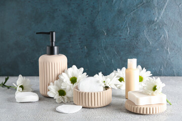 Composition with cosmetic products, cotton pads and chamomile flowers on table