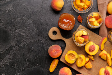 Jars with sweet peach jam and fresh fruits on black background