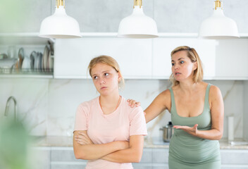 Blurry unrecognizable angry mother yells at teenage girl. Concept of generational conflict. Sad...