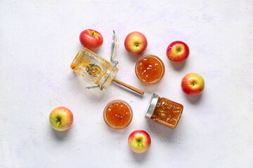 Glass bowls and jars of sweet apple jam on white background
