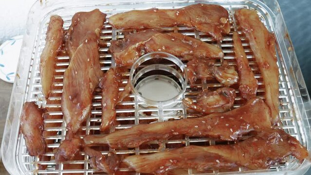 Home cooking Chicken slices while dehydrating making jerky in Dehydrator.