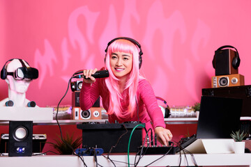 Artist with pink hair mixing techno song with electronic using professional turntables while...