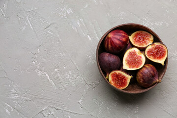 Bowl with fresh ripe figs on grey background
