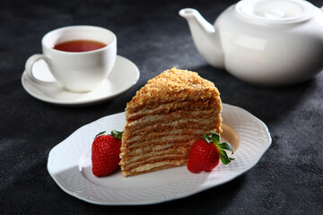 Piece of honey cake on plate. White porcelain tableware. Space for copying.Selective focus