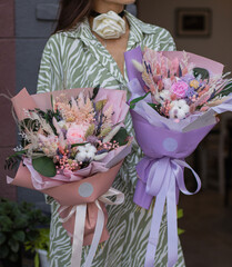 Girl holding two beautiful flower bouquets with preserved flowers and dried flowers. Valentine's, women's, mother's day, 8th of march. 14th of february. Teacher's.