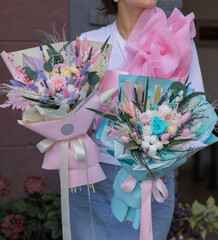 Girl holding two beautiful flower bouquets with preserved flowers and dried flowers. Valentine's, women's, mother's day, 8th of march. 14th of february. Teacher's.
