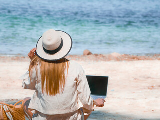 young woman uses laptop computer on the beach. distance work, freelancer and blogger concept. WiFi unlimited