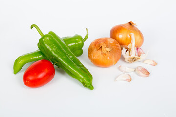 Still life on white background of vegetables, onions, peppers, garlics