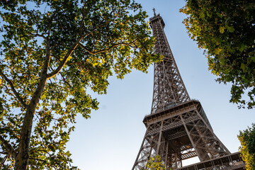 The Eiffel Tower seen through trees with a beautiful summer sky in the background, Paris, France.