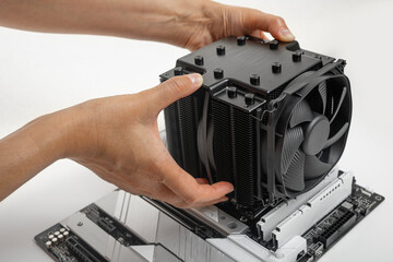 Installing a large air cooler on a computer processor.