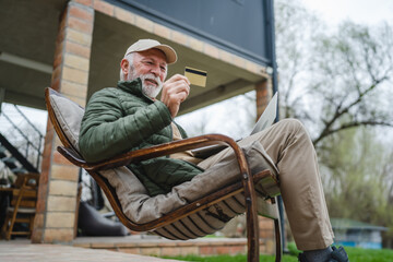 Man senior caucasian male shopping online sit with laptop computer