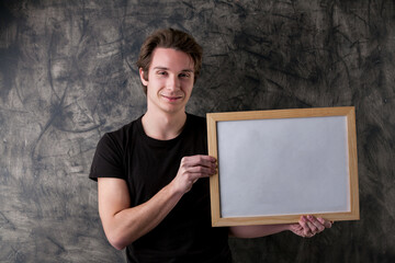 Smiling educator showcases copyspace, erased blackboard behind