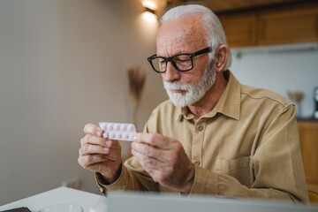 One man senior caucasian male hold medicine drugs tablet read label