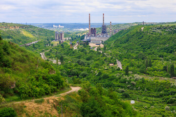 Fototapeta na wymiar Plant or factory. Industrial area in a picturesque beautiful green area. Background with selective focus and copy space
