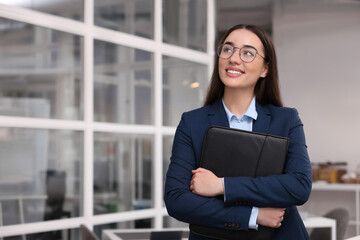 Happy real estate agent with leather portfolio indoors. Space for text