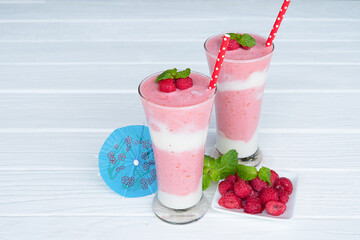 Raspberry smoothie red colorful fruit juice milkshake blend beverage healthy high protein the taste yummy In glass drink episode morning on white wood background.