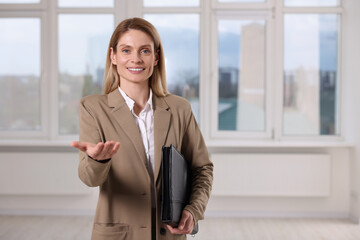 Happy real estate agent with leather portfolio indoors. Space for text