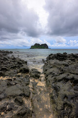 fiji island under blue cloudy sky across rocky beach