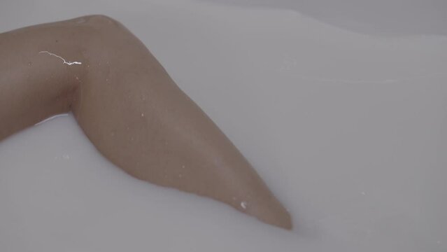 Close up of a woman's legs in a milky bath