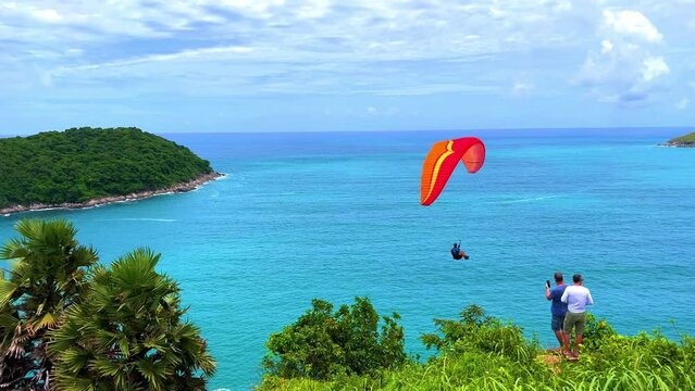 Parra  Glider at Ya Nui Beach and Nai Harn Beach in Phuket Thailand, turquoise blue waters, lush green mountains colourful skies. Phuket is a tropical island 