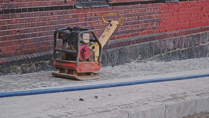 City Road Works Construction Site with Equipment Ground Compactor Machine Stored Outdoors on Street