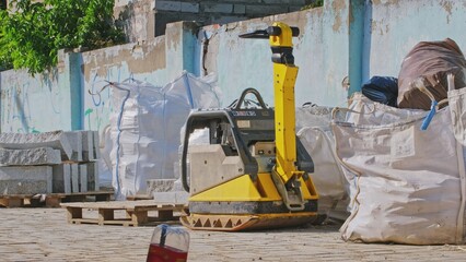 Road Works Construction Site with Materials and Equipment Ground Compactor Machine Stored Outdoors on Street