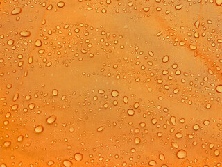 Orange fabric texture with water drops. Waterproof fabric