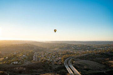 wide shot of sunset with hot air balloon centered in frame of tour
