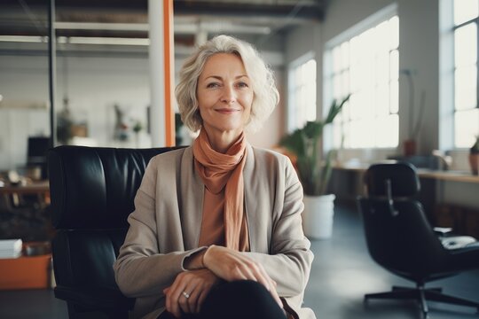 Smiling portrait of a happy senior woman working for a startup company in an office
