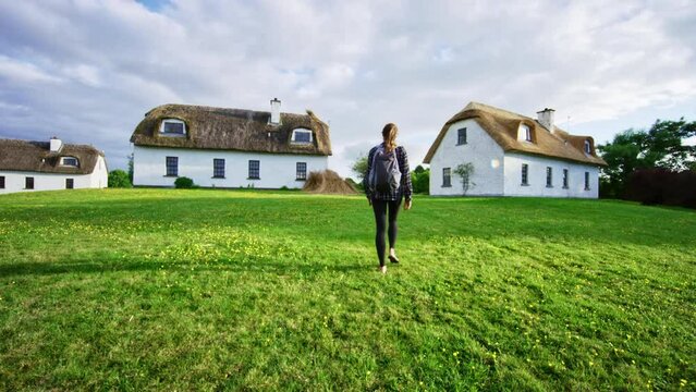 Woman Walking Towards Old Irish Homes In Slow Motion