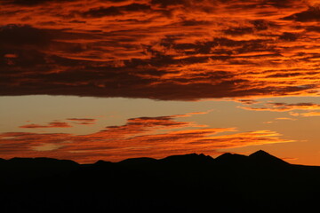 Vibrant Sunset Casting a Silhouetted Mountain Landscape