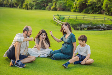 Fototapeta premium A loving family enjoying a leisurely walk in the park - a radiant pregnant woman after 40, embraced by her husband, and accompanied by their adult teenage children, savoring precious moments together