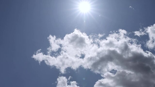 blue sky with white clouds and bright sunlight, clouds against a blue spring sky
