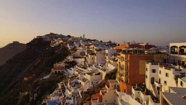 Aerial view of Santorini, Greece, caldera cliffs, with amazing sunset. Cinematic 4k