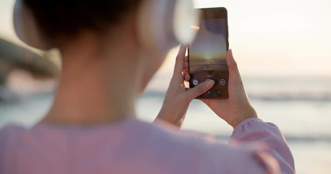 Phone, sunset and photograph with a woman at the beach for freedom, travel or vacation in the morning. Nature, summer and social media with a young female tourist by the ocean for a profile picture