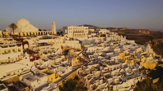 Aerial View of traditional White Houses in Santorini Island, Greece, at sunset. Cinematic 4k.