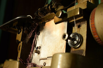 Close up an antique Swan Overlock Sewing Machine on the wooden desk.