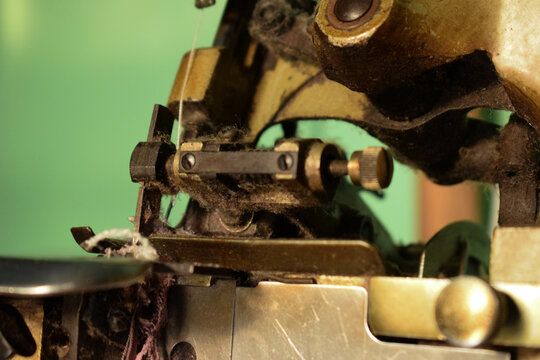 Close up an antique Swan Overlock Sewing Machine on the wooden desk.