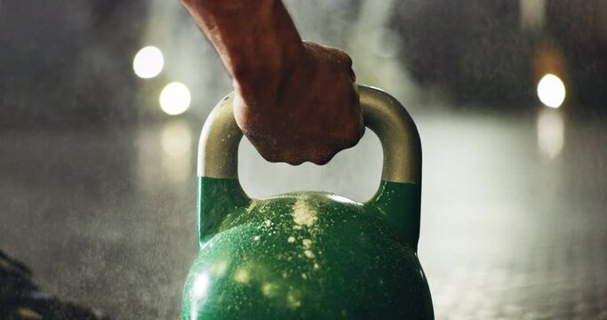 Fitness, training and closeup of hand on kettlebell for weightlifting exercise in a gym. Strength, health and zoom of sports athlete body builder with weight equipment for muscle workout or exercise.