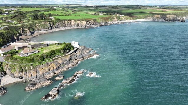 Ireland Coast aerial establishing shot of a sheltered fishing harbour at Boatstrand Copper Coast Waterford on a bright summer day