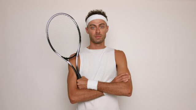 Portrait of a young tennis player with racket on white background.
