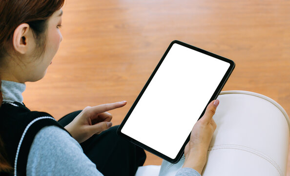 Mockup image of asian woman holding black digital tablet with blank white screen at home.