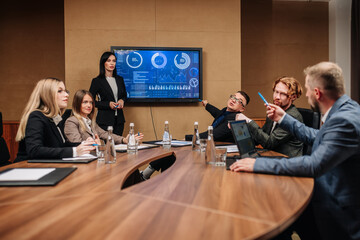A diverse multinational team of professional business people meet in the conference room of a...