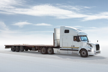 White long-distance bonnet truck with a semitrailer isolated on bright background with sky