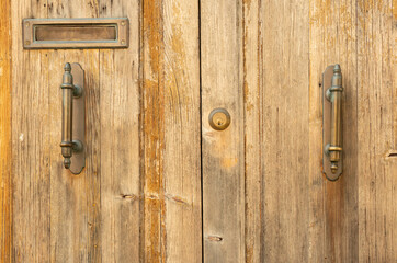 Part of an old wooden door with metal handles