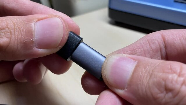 Close up view male hands fingers connect USB type C to USB adaptor and disconnect them 