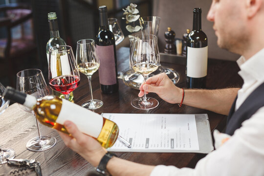 Wine steward expertises alcoholic beverage. Closeup.