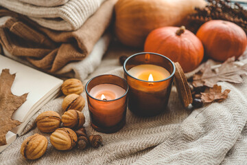Two burning candles in the autumn interior
